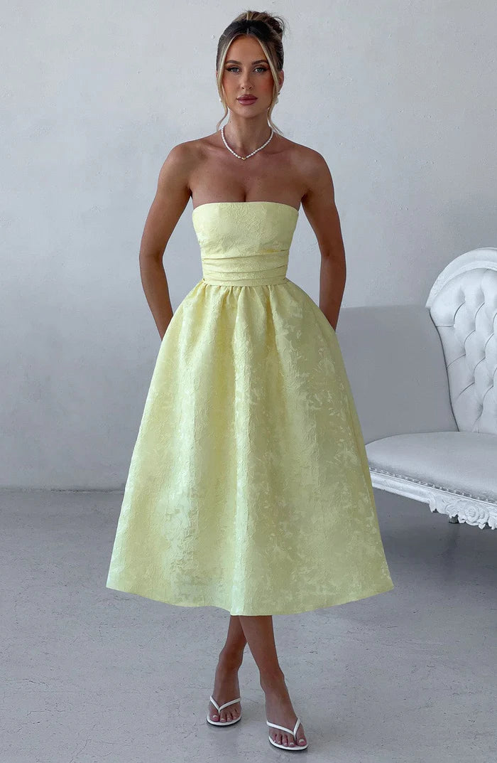 Experience year-round elegance with the Saoirse Dress. This playful strapless dress in Lemon features a boned bodice and full tulle-lined skirt, complete with gathered and pleated details. Perfect for any occasion, pair with heels and an updo for a chic look.