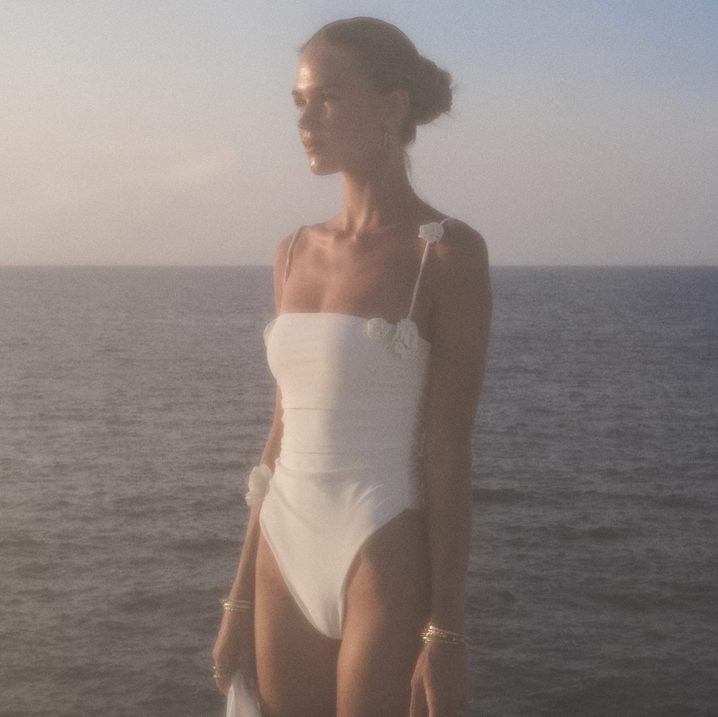 This alluring Swimsuit Rose is the epitome of sophistication and exclusivity. Its form-fitting design and smooth, white thong accentuate the curves of the female body, complemented by a sleek Brazilian cut. The perfect choice for a beach day or poolside lounging, this one-piece exudes luxury and elegance.