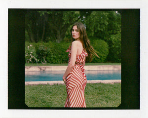 Indulge in the timeless charm of Theodora Maxi Dress. Its one-shouldered design and silk candy stripes evoke a sense of theatrical elegance. Panelled seams create an abstract stripe pattern in cream and deep red hues. Cinch the waist for added allure and pair with a dark lip and pointed heels for a touch of old-school Parisian chic.