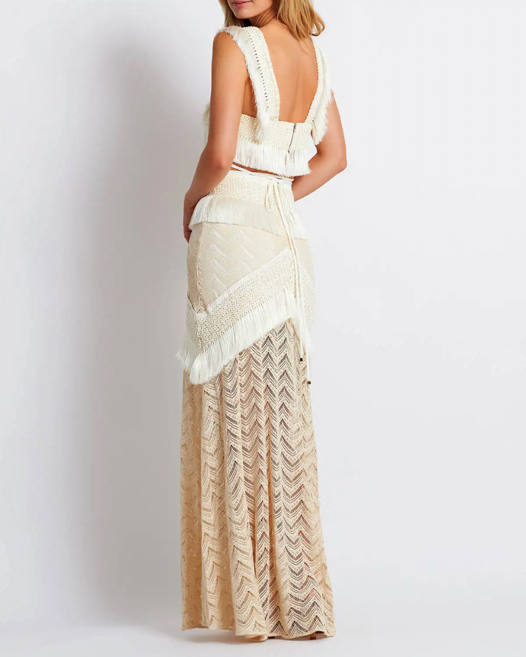 Experience elegance and boho-chic with our Fringe Trim Maxi Ensemble. Perfect for seaside parties and lively festivals, this ensemble is made from stretch modal lace and features a concealed back zip for a seamless finish. The playful fringe trims on the skirt add a touch of movement to elevate your look.