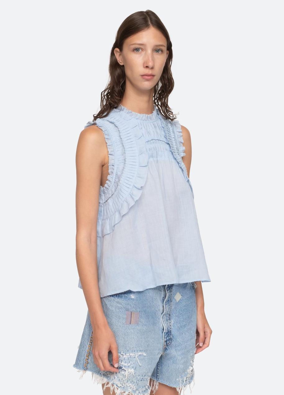 Elevate your wardrobe with the Cole Tank by Sea New York. This sleeveless tank features delicate smocked detailing and ruffle accents, giving it a romantic and feminine feel. The flutter sleeves add a touch of whimsy to this elegant top, making it the perfect addition to your collection. Designed for an effortless yet refined look.