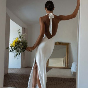 Dress Goldie is the perfect choice for modern brides. Featuring a stunning halter neckline and sleeveless design, this simple mermaid wedding dress is made of high-quality satin material and boasts an open back and high side slit for added elegance. With its floor length, it's sure to make a lasting impression on your special day.