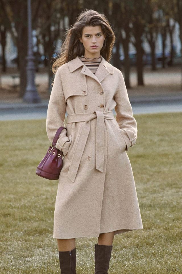 Indulge in luxury with the Manteaux Elisa. This long coat with a classic beige herringbone pattern and a belted waist exudes elegance. The cross-over collar, button details on the cuffs, and back slit add sophistication. Elevate your style with this statement piece.