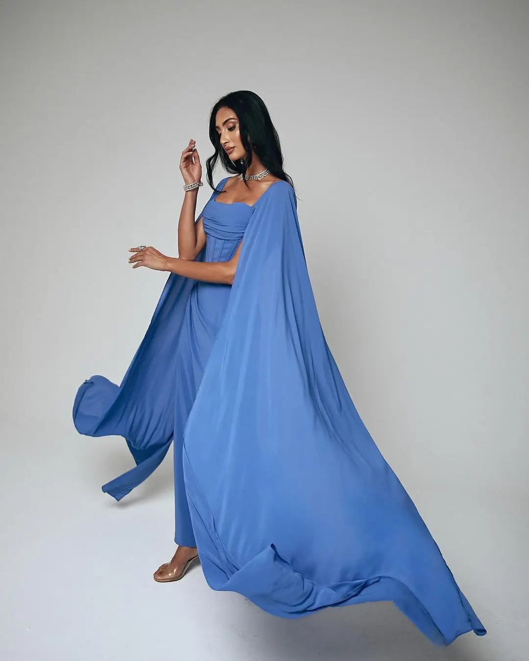 Elevate your style with Dress Rosine. Its square neckline and elegant design create a flattering silhouette. The floor length hem and ruffle details add a touch of elegance. And with a court train and zipper closure, it's the perfect choice for any formal occasion. Make a statement in blue.