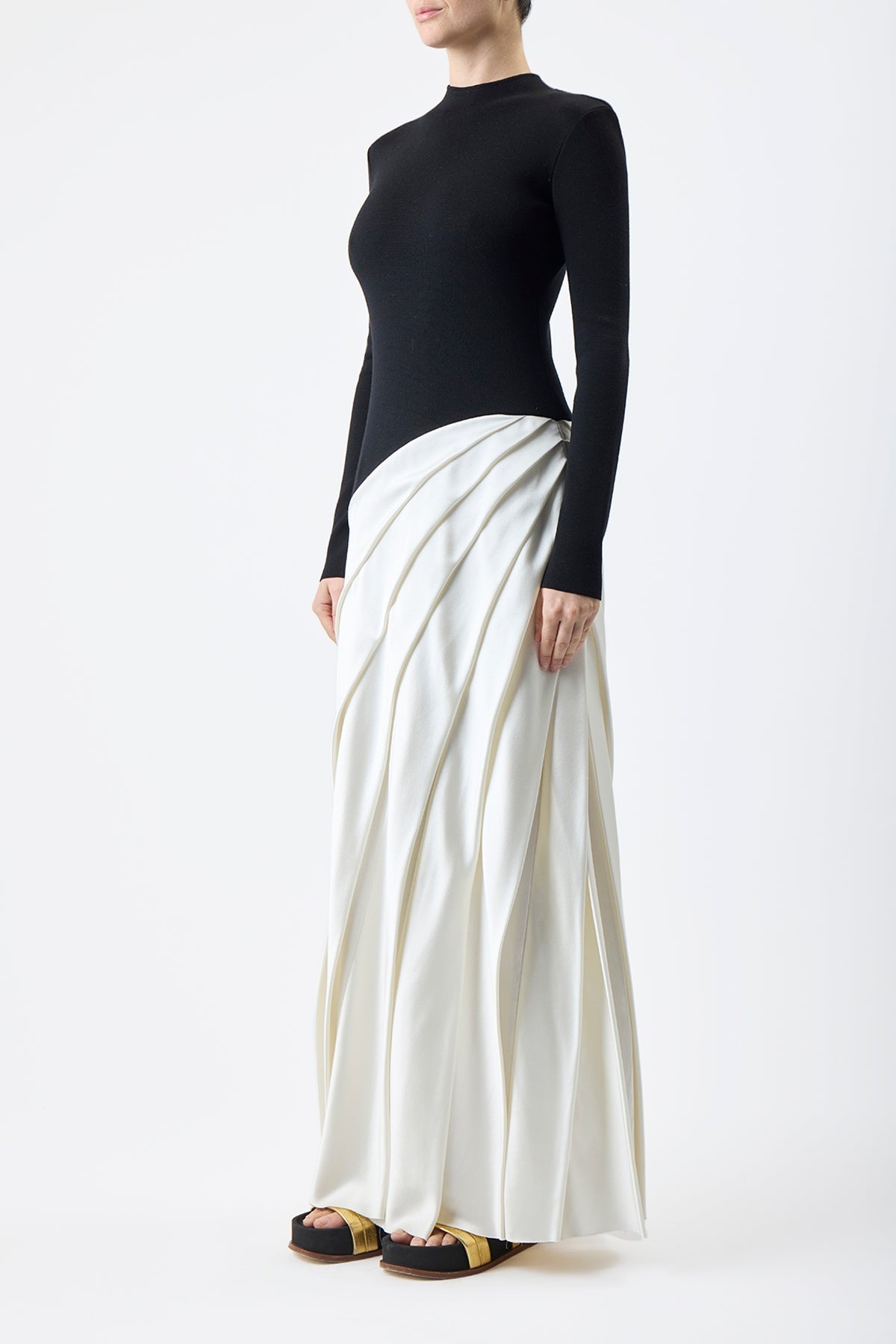 Indulge in luxury with the Ismay Silk Pleated Maxi Dress by Gabriela Hearst. This elegantly crafted piece boasts a clever design, featuring a black silk knitted bodice and a white pleated satin skirt for a striking contrast. The sharp pleats create beautiful movement as you walk, while the mock neckline adds a touch of sophistication. Perfectly paired with classic pumps for a timeless look.