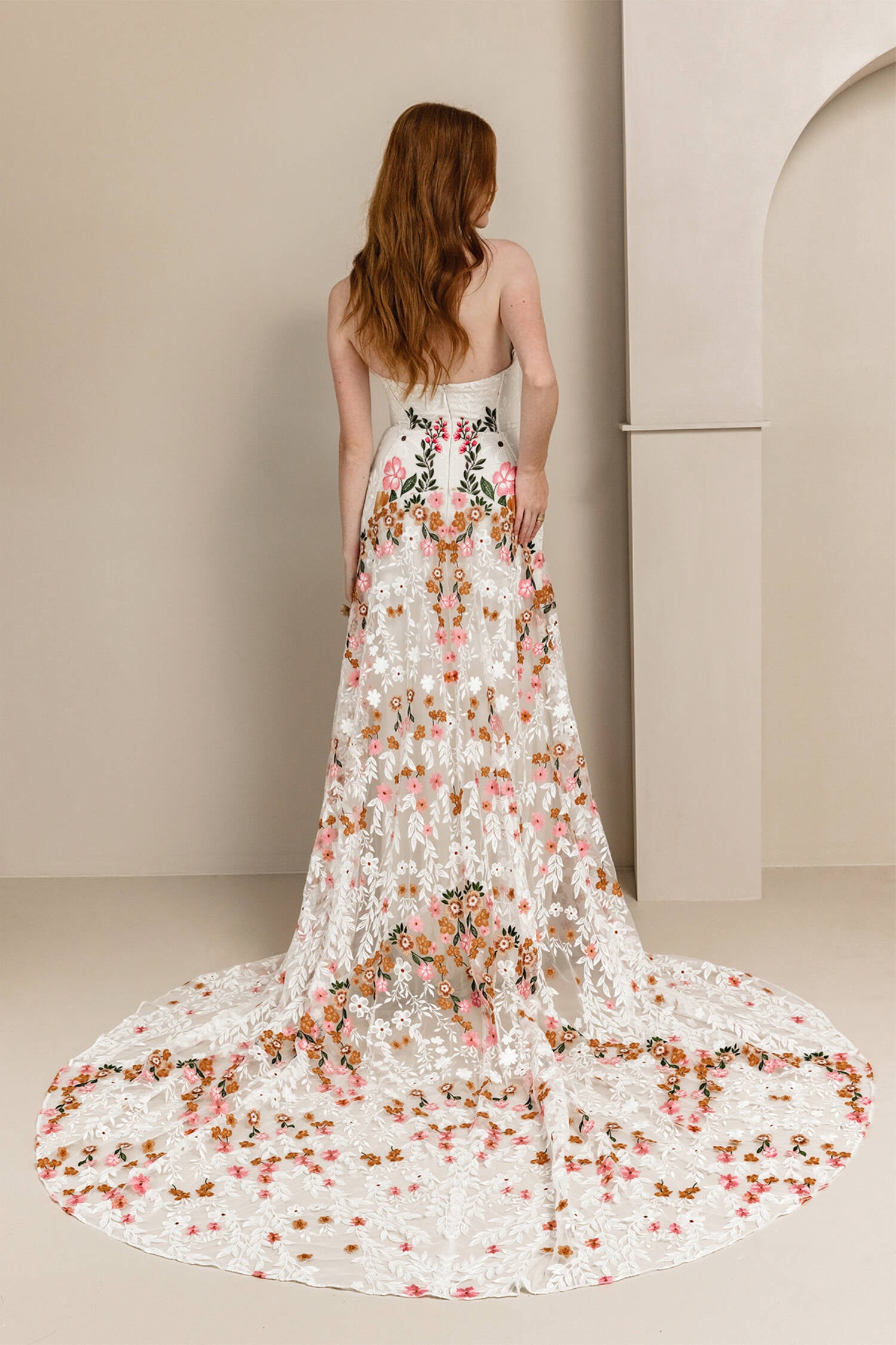 Introducing Meadow Gown - a work of art inspired by desert blooms. Its vibrant florals are delicately embroidered on sand-dyed tulle, creating a stunning contrast against bare terrain. With a fully boned bodice for support and a dramatic train with cascading flowers, this gown exudes a playful yet sophisticated charm. Perfect for the bold bride looking to infuse color into her special day.