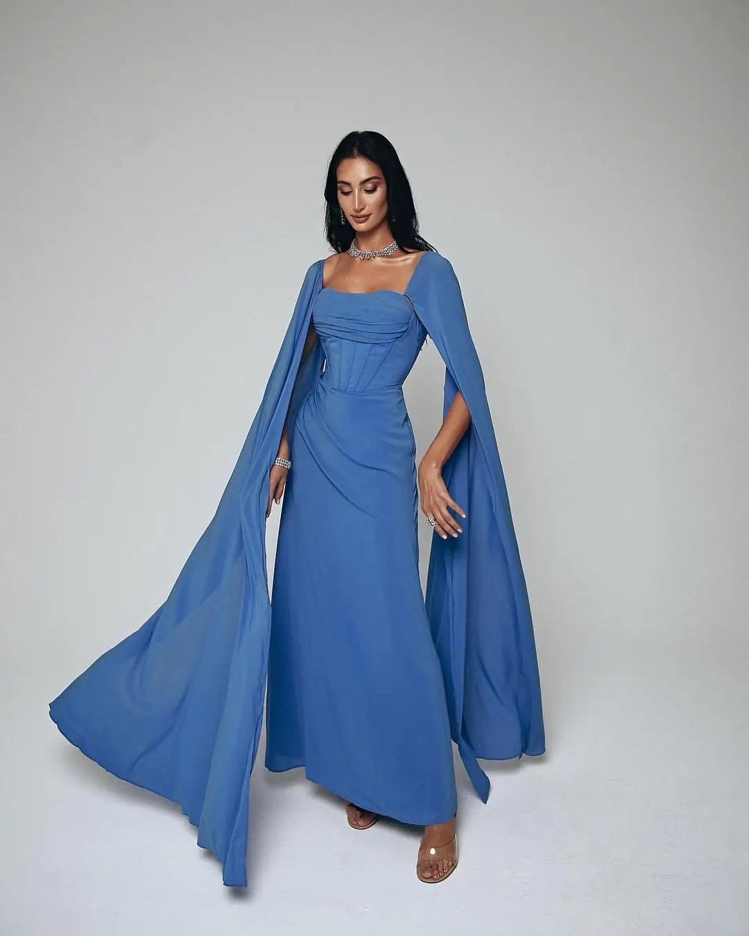 Elevate your style with Dress Rosine. Its square neckline and elegant design create a flattering silhouette. The floor length hem and ruffle details add a touch of elegance. And with a court train and zipper closure, it's the perfect choice for any formal occasion. Make a statement in blue.