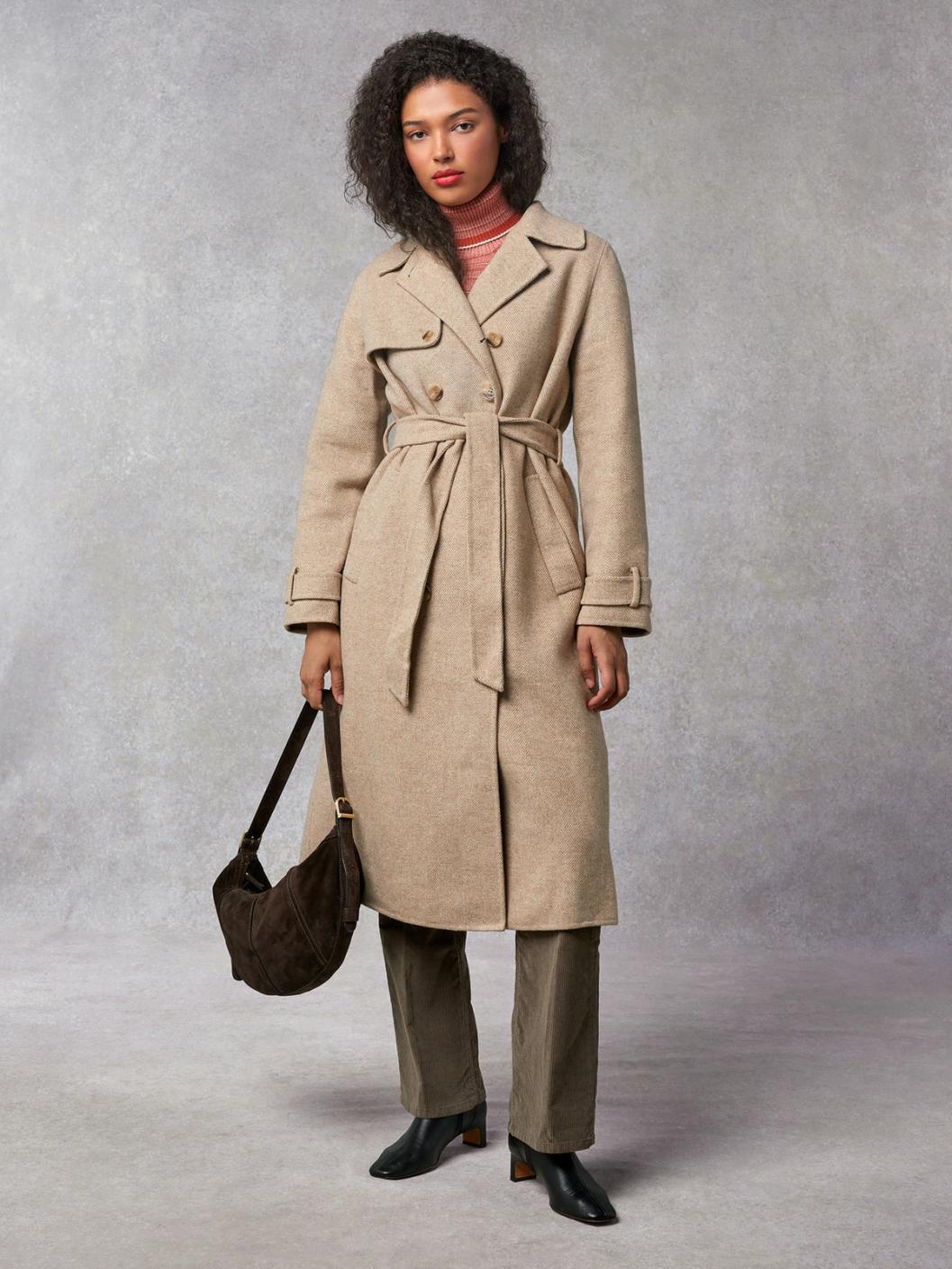 Indulge in luxury with the Manteaux Elisa. This long coat with a classic beige herringbone pattern and a belted waist exudes elegance. The cross-over collar, button details on the cuffs, and back slit add sophistication. Elevate your style with this statement piece.