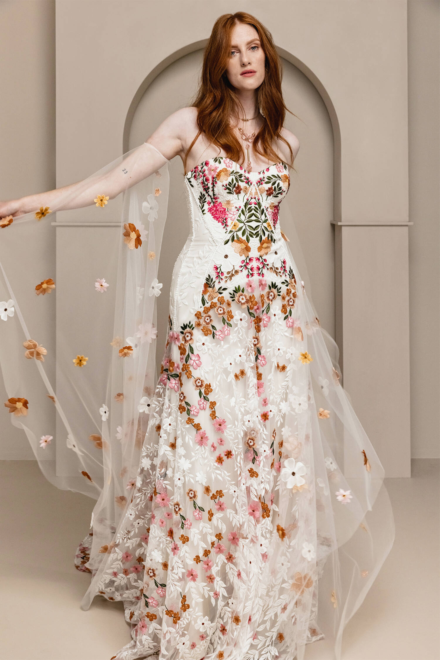 Introducing Meadow Gown - a work of art inspired by desert blooms. Its vibrant florals are delicately embroidered on sand-dyed tulle, creating a stunning contrast against bare terrain. With a fully boned bodice for support and a dramatic train with cascading flowers, this gown exudes a playful yet sophisticated charm. Perfect for the bold bride looking to infuse color into her special day.