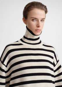 Unleash your fashion-forward style with the Striped Wool Jersey by Toteme. Crafted from heavyweight wool and organic cotton, this turtleneck sweater boasts a striking sand and black striped pattern. Certified by the Responsible Wool Standard, its boxy silhouette, tall neck, and extra-long sleeves with dropped shoulders exude luxury and sophistication. Leave the neck undone for an effortlessly chic look.