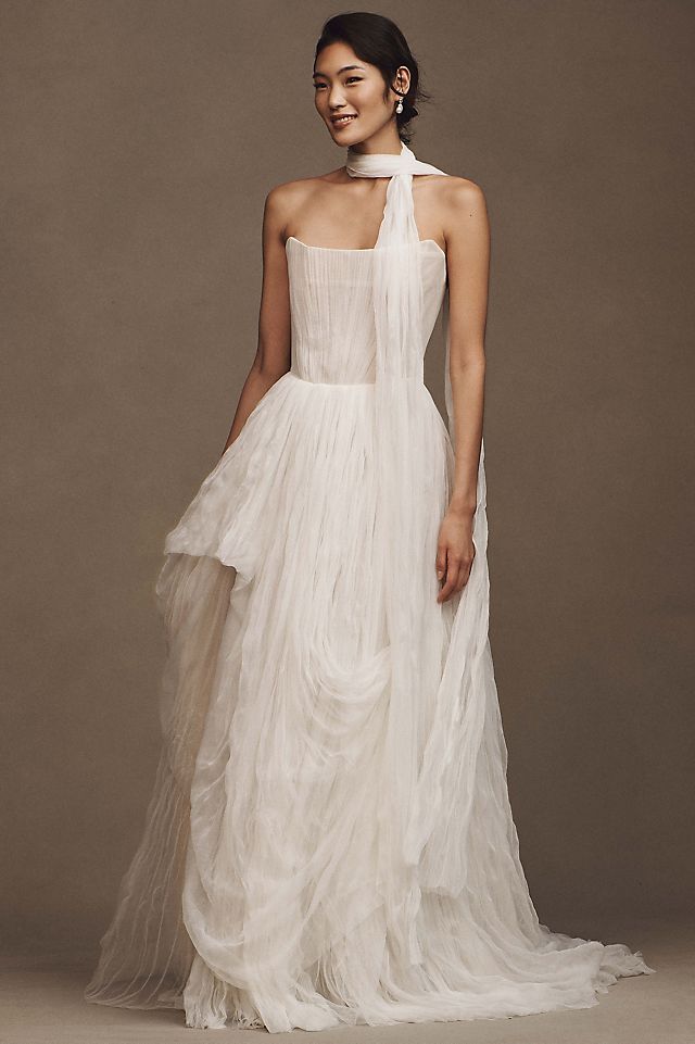 Elevate your wedding day look with the Klelia Gown. Its soft netting, Georgian-style corsetry, and delicate tucks exude both romance and structure. Contemporary style meets timeless charm in the ballgown silhouette, while modern design sensibilities add a touch of uniqueness. Make a statement on your special day with this reimagined classic.