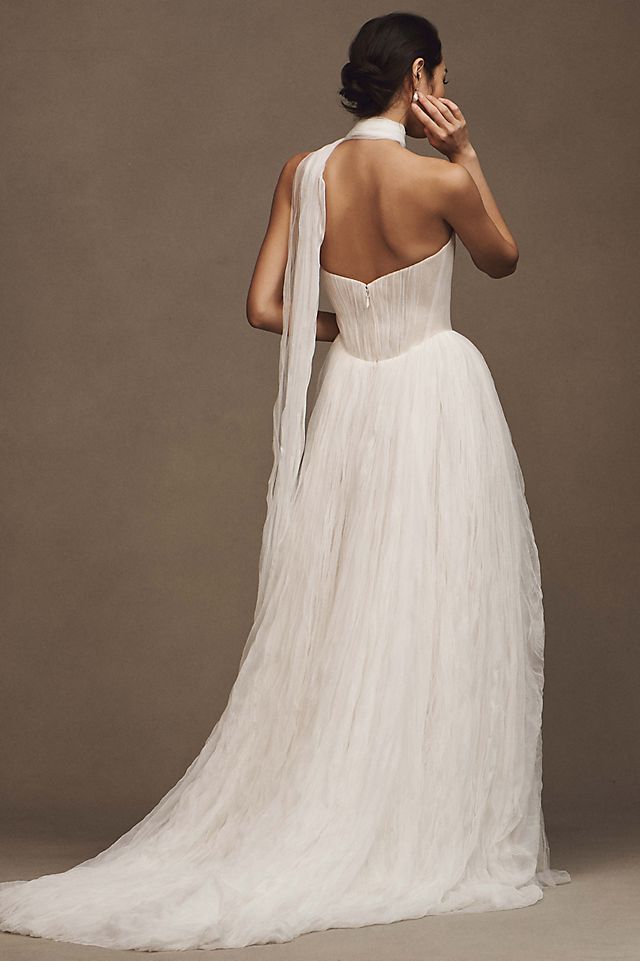 Elevate your wedding day look with the Klelia Gown. Its soft netting, Georgian-style corsetry, and delicate tucks exude both romance and structure. Contemporary style meets timeless charm in the ballgown silhouette, while modern design sensibilities add a touch of uniqueness. Make a statement on your special day with this reimagined classic.