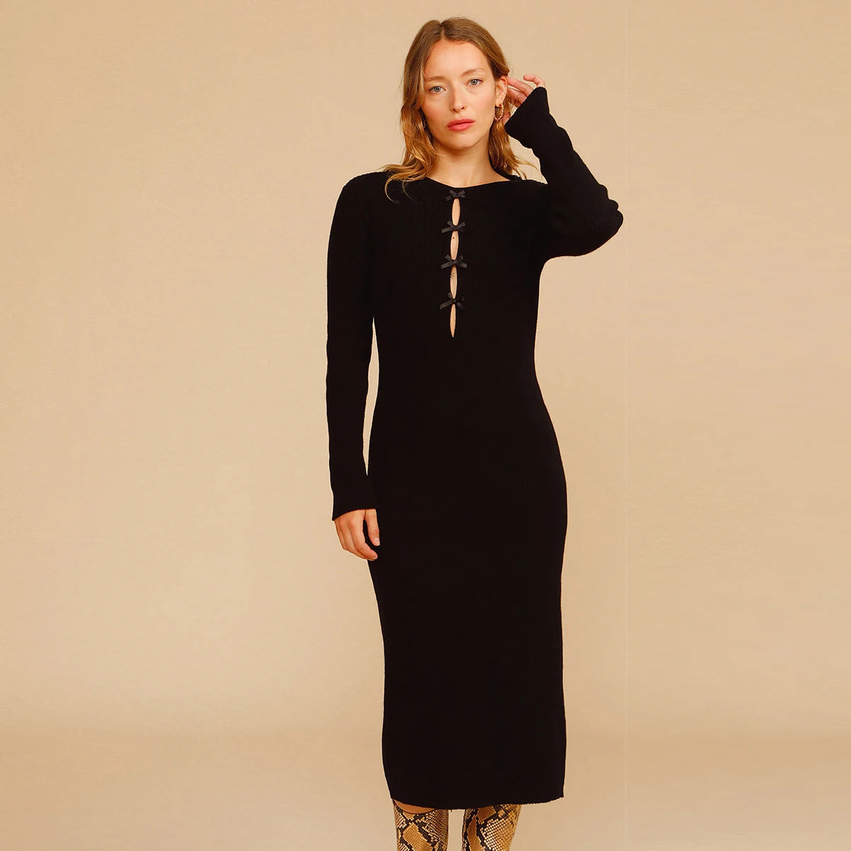 Experience effortless chic this autumn and winter with our Elona Midi Dress. Made from high-quality rib knit fabric, this vintage cutout dress features a figure-hugging silhouette, cascading cut-outs with bows, and a crew neckline. Perfect for work from home or dressing up on off-duty days. Complete the look with mid-calf heeled boots and a snakeskin baguette bag.