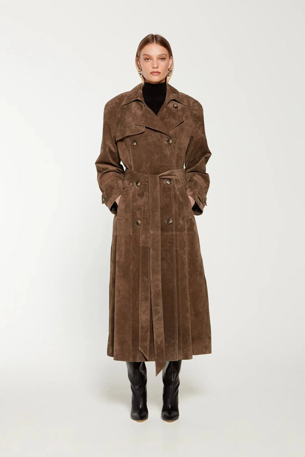 Elevate your style with the Corrin Suede Trench Coat by Ducie. Crafted from luxurious suede leather, this double breasted trench is complete with a storm flap and leather sash for a sophisticated touch. Its cocooning design and satin lining make it a timeless addition to your wardrobe.