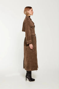 Elevate your style with the Corrin Suede Trench Coat by Ducie. Crafted from luxurious suede leather, this double breasted trench is complete with a storm flap and leather sash for a sophisticated touch. Its cocooning design and satin lining make it a timeless addition to your wardrobe.