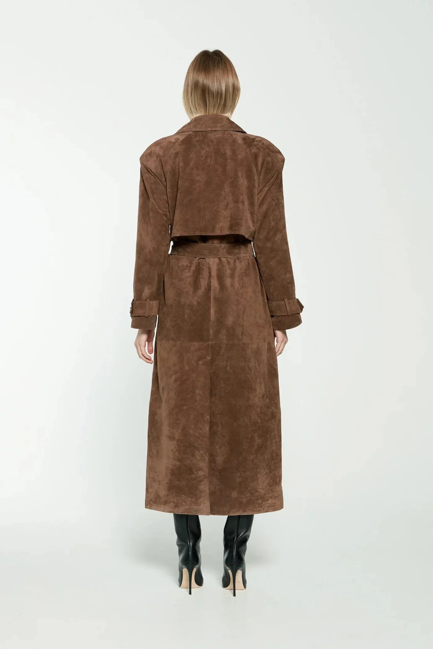 Elevate your style with the Corrin Suede Trench Coat by Ducie. Crafted from luxurious suede leather, this double breasted trench is complete with a storm flap and leather sash for a sophisticated touch. Its cocooning design and satin lining make it a timeless addition to your wardrobe.