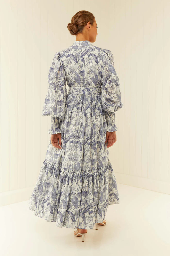 Be the center of attention at your next event with our Royal Flush Dress. Made from 100% Linen Scallop, this maxi dress features a unique Jungle Blue print, functional buttons, and blouson sleeves with elasticated cuffs. Complete the look with the included eyelet belt. Expertly crafted for a statement-making look.