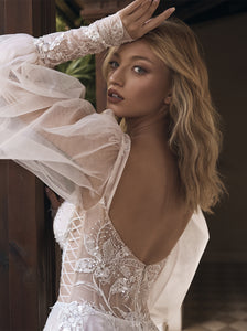 Showstopping sheer lantern sleeves aren't the only wow-worthy aspects of this dreamy wedding dress. The romantic A-line silhouette, fitted corset top with square neckline, cutout details, and lace embellishments make Pipa an undeniably chic option—finished in an embroidered ivory and silver tulle.