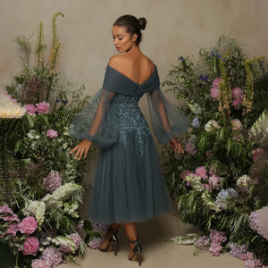 Elevate your style with the Della Dress. The off-the-shoulder bodice and plunging neckline exude confidence, while the bishop sleeves add a touch of drama. The tulle skirt with shiny lace detail accentuates your curves and adds a daring flair. Make a statement at your next event in this charming gown.