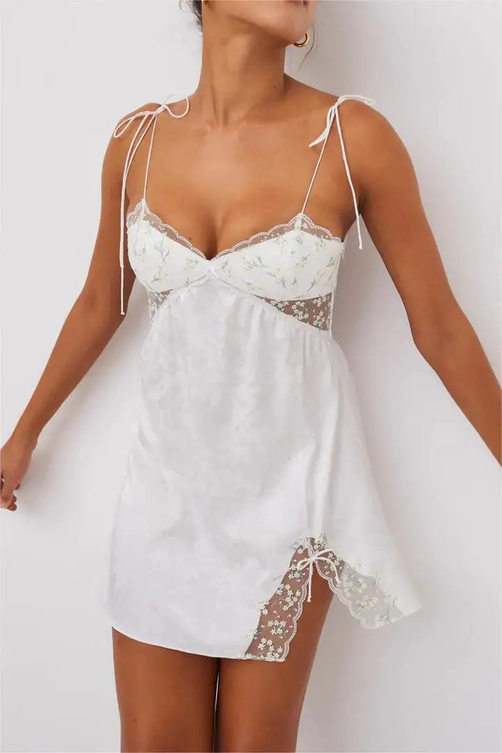 A spray of baby’s breath blooms lends a delicate romance to this pure white mini slip. Featuring embroidered tulle, luxe satin jacquard, ultra skinny tie straps, and a side slit for a look that’s not-so-innocent. FOR LOVE &amp; LEMONS FOR VICTORIA’S SECRET: An exclusive collaboration that blends dreamy confidence with thoughtful detailing, giving each piece a unique and feminine feel.