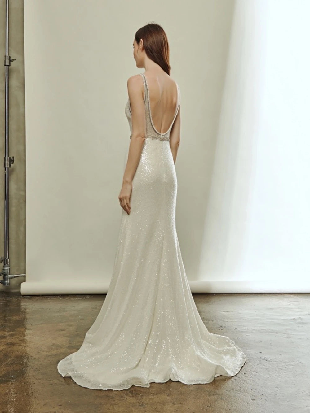 Indulge in the luxurious allure of the Robe Ivonne. This stunning wedding dress features a sexy deep V-neck and a backless design, perfect for showcasing your curves. Embellished with sparkly sequins, this robe exudes elegance and grace. Slip into this mermaid style gown and feel like a glamorous bride on your special day.