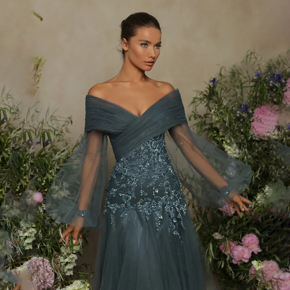 Elevate your style with the Della Dress. The off-the-shoulder bodice and plunging neckline exude confidence, while the bishop sleeves add a touch of drama. The tulle skirt with shiny lace detail accentuates your curves and adds a daring flair. Make a statement at your next event in this charming gown.