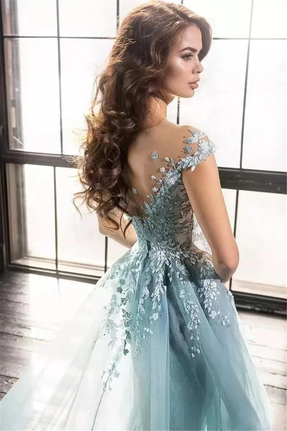 Expertly crafted with intricate blue illusion lace and beaded appliques, the Robe Marigold is a stunning prom dress for a luxurious evening. The flowing court train adds an elegant touch while showcasing your figure. Make a statement in this long, glamorous gown.