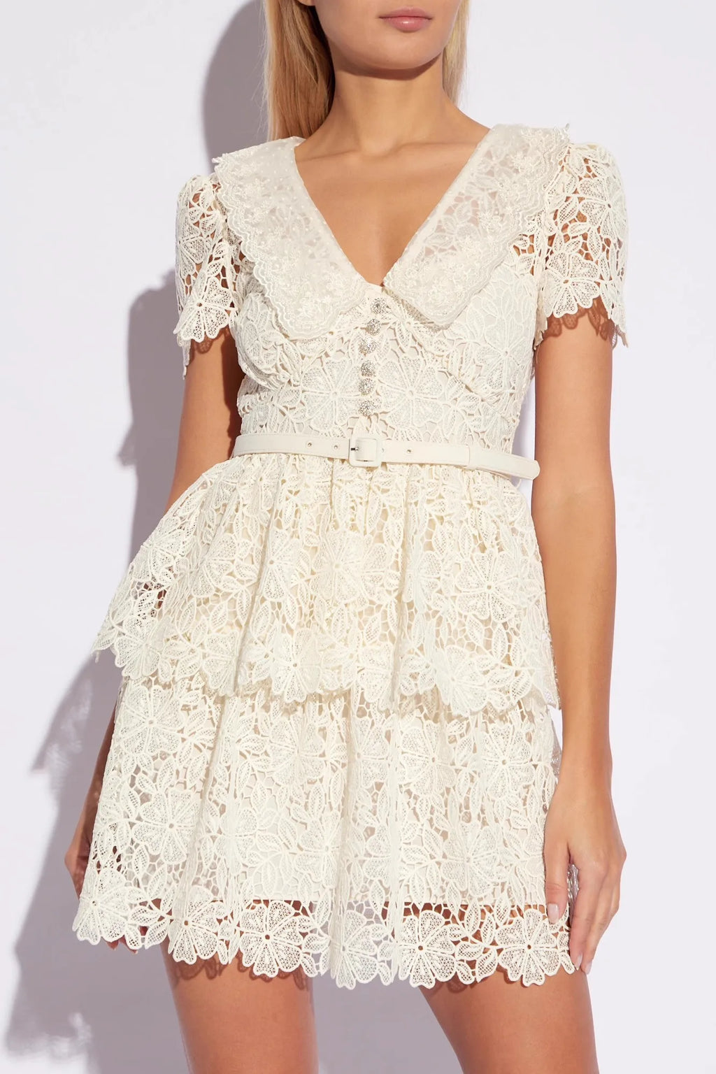 Introducing Flower Lace Mini Dress by Self-Portrait - a reimagined classic for the modern woman. Embodying a signature sensuality and ease, this elegant dress features delicate lace embroidery, feminine short sleeves, and a flattering v-neck. Complete with a sash for added style, it's perfect for any summer occasion.