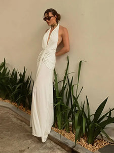 Indulge in luxury with the Dress Safiya. This stunning maxi dress features a seductive backless design, halter neckline, and pleated detailing. With a deep V-neck and sleeveless cut, this dress exudes sophistication and sensuality. Elevate your fashion game and turn heads at any event with this elegant and exclusive piece.