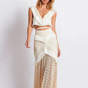 Experience elegance and boho-chic with our Fringe Trim Maxi Ensemble. Perfect for seaside parties and lively festivals, this ensemble is made from stretch modal lace and features a concealed back zip for a seamless finish. The playful fringe trims on the skirt add a touch of movement to elevate your look.