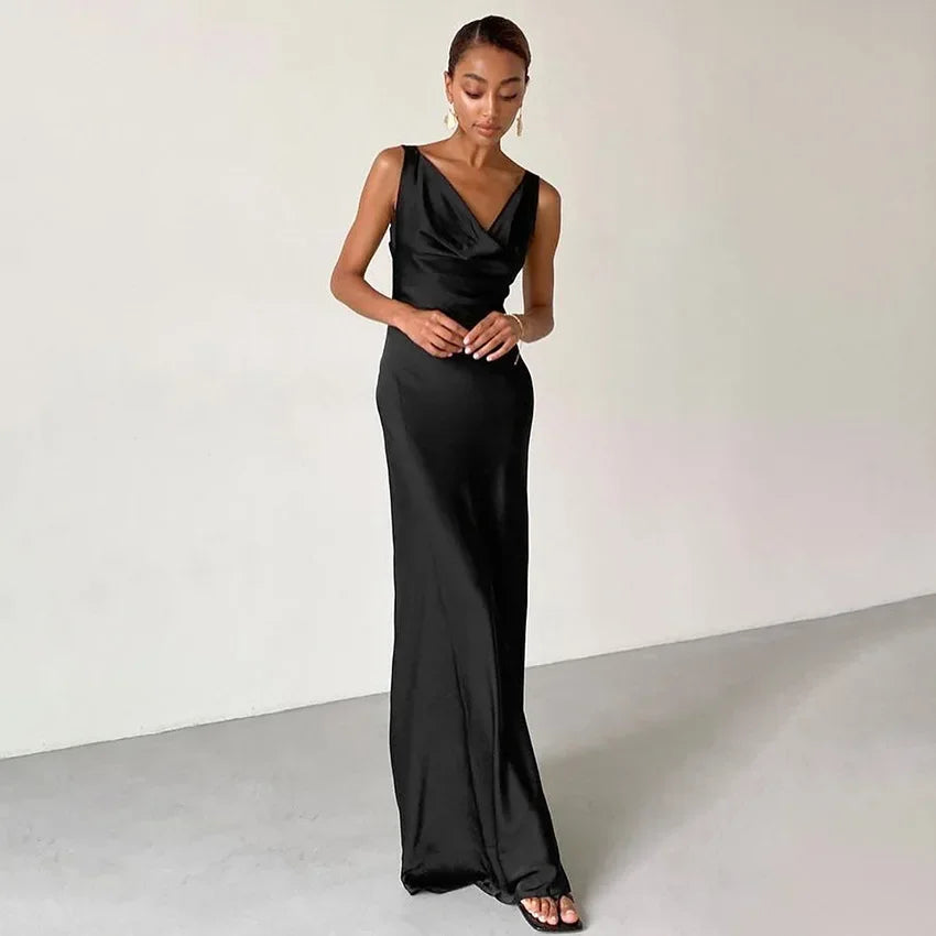 Introducing the Norma Dress, the ultimate combination of elegance and comfort. This black high-waisted long dress is made of luxurious satin, perfect for any special occasion. With its sleeveless design, you can effortlessly move and dance the night away. Elevate your style with the Norma Dress.