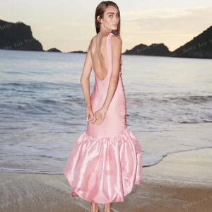 The Bahia Dress is perfect for any occasion with its beautifully crafted sleeveless design and light pink bundage satin material. Its mermaid silhouette will flatter any figure, and the open back adds a touch of elegance. The cascading folds and maxi length make this dress a timeless choice for any woman's wardrobe.