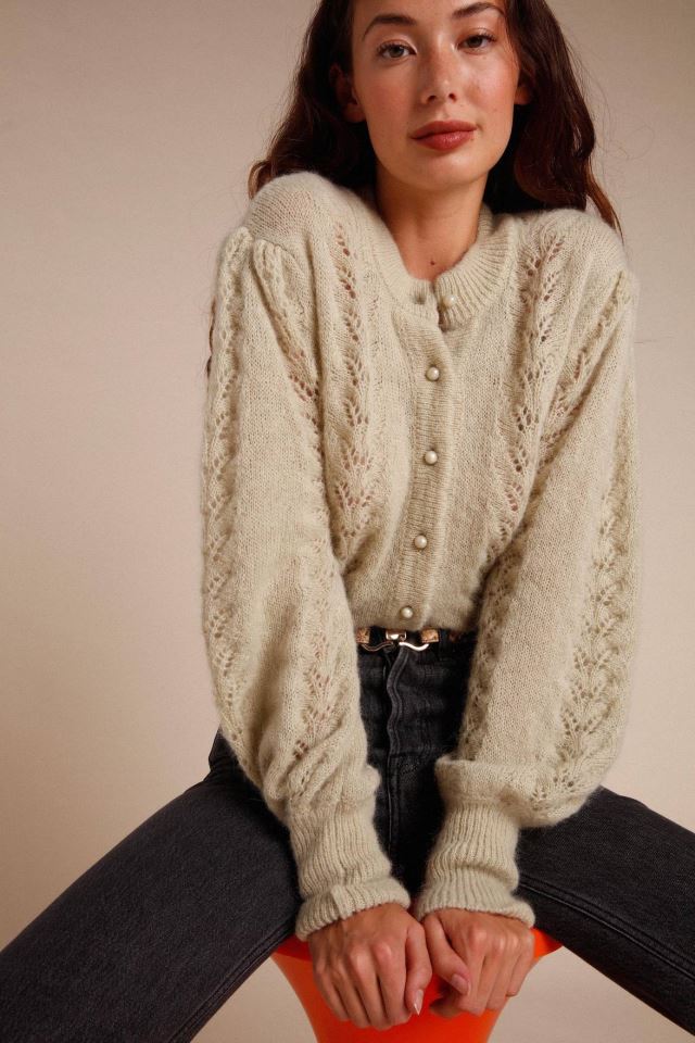 Indulge in the luxury of our Maddy cardigan. This intricately knitted piece features a delicate lace design, a round neckline, and long sleeves. The scalloped edges add a touch of elegance to the button details. Stay stylish and cozy with this must-have addition to your wardrobe.