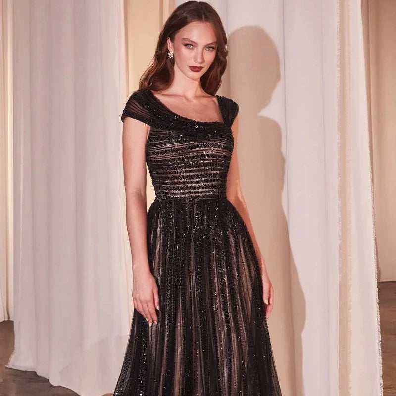 Indulge in elegance with our Chiara Gown, designed for the daring and bold. Featuring an off-the-shoulder asymmetrical bodice with dazzling horizontal beading, and a layered tulle skirt adorned with a vertical beaded motif, this dress exudes modern glamour. Whether it's a gala or special evening, make a statement in this captivating and timeless piece.