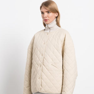 Elevate your wardrobe with the TOTEME drop-shoulder diamond-quilted jacket. Crafted from original cotton material, this jacket boasts a luxurious diamond texture and a chic snap button design. The perfect combination of style and comfort, this coat is a must-have for any fashion-forward individual.