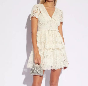 Introducing Flower Lace Mini Dress by Self-Portrait - a reimagined classic for the modern woman. Embodying a signature sensuality and ease, this elegant dress features delicate lace embroidery, feminine short sleeves, and a flattering v-neck. Complete with a sash for added style, it's perfect for any summer occasion.