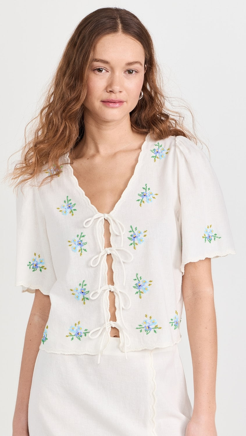 Introducing the Tania Beaded Top by SEA! Made from a lightweight, non-stretch slubbed weave, this top features stunning floral glass beading throughout, with delicate tonal embroidery along the scallop edges. The tie placket and v neck add a touch of femininity, while the short sleeves keep you cool and comfortable. Elevate any outfit with this beautiful top!