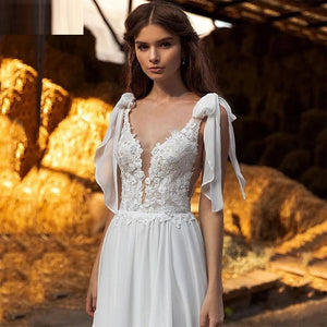 The Robe Mahala effortlessly combines princess and boho styles, featuring delicate lace, a deep V-neck, and a soft chiffon fabric. Its spaghetti straps and high split add a touch of elegance, perfect for any wedding. Feel like a royalty on your special day with this beautiful dress.