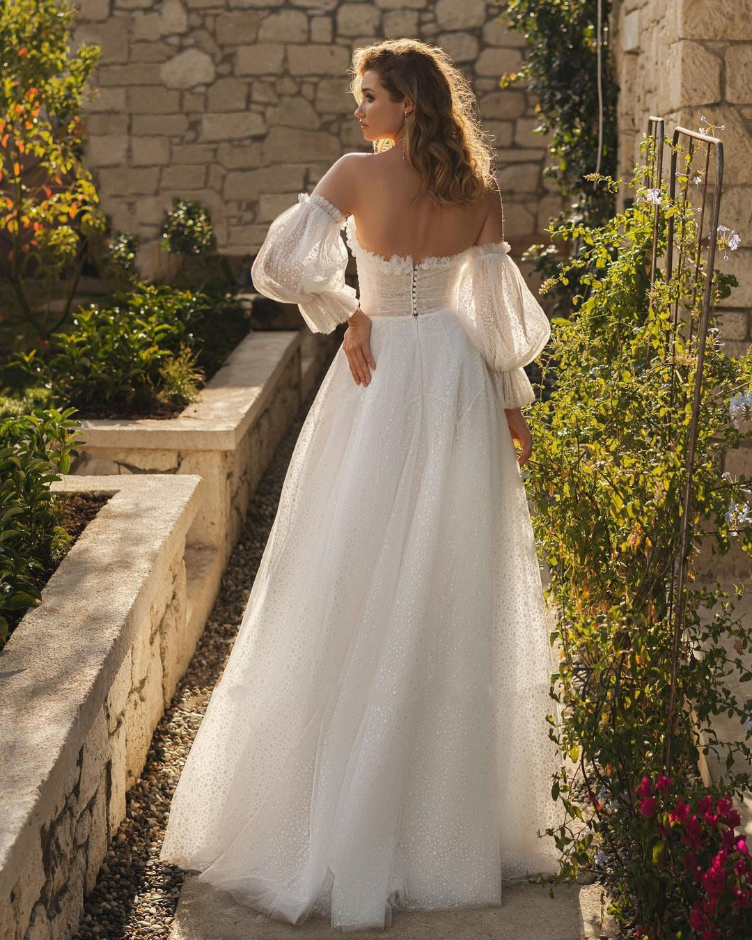 Get ready to turn heads in the Robe Alara! With its off-shoulder, sweetheart neckline and A-line silhouette, this bohemian wedding dress is both chic and comfortable. The delicate lace and long sleeves add an extra touch of romance, while the buttons down the back and floor-length skirt create a stunning finishing touch. Say yes to style and comfort on your special day!