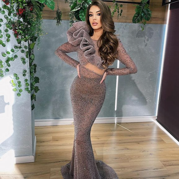 The Robe Endellion is a fabulous way to shine! This mesmerizing Mermaid evening dress features long lace sleeves, sequins, and tassels to create an unforgettable ensemble. Make your special night sparkle with a style that's equal parts sassy and sparkly!