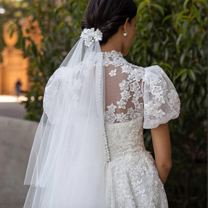 Introducing the Robe Riah - a stunning wedding dress with puff sleeves and a sparkling princess cut design. This luxurious garment exudes elegance and sophistication, making any bride feel like royalty on her special day. Experience the ultimate in bridal couture with the Robe Riah.