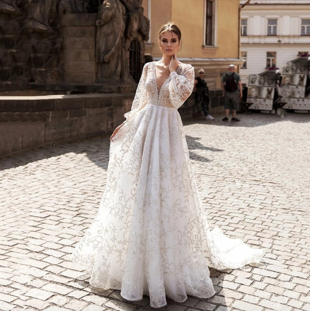 Be the belle of the ball in our luxurious Robe Anica. With its A-line silhouette, long sleeves, and plunging back and neckline, this deluxe wedding dress is sure to turn heads. Perfect for the unconventional bride who wants to make a statement on her special day!