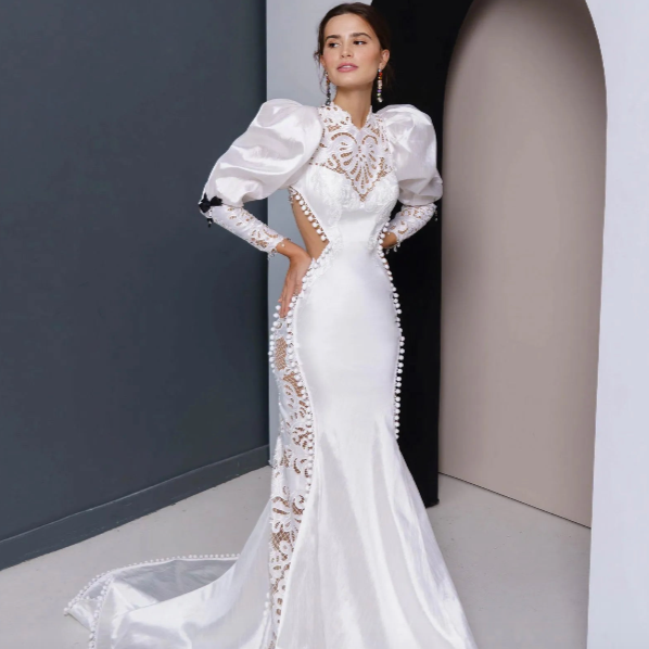 Indulge in luxury and elegance with the Robe Ursulla. This exquisite bridal gown boasts an enchanted mermaid silhouette, adorned with delicate lace details and long sleeves. Enter your special day with sophistication and grace in this enchanting robe.