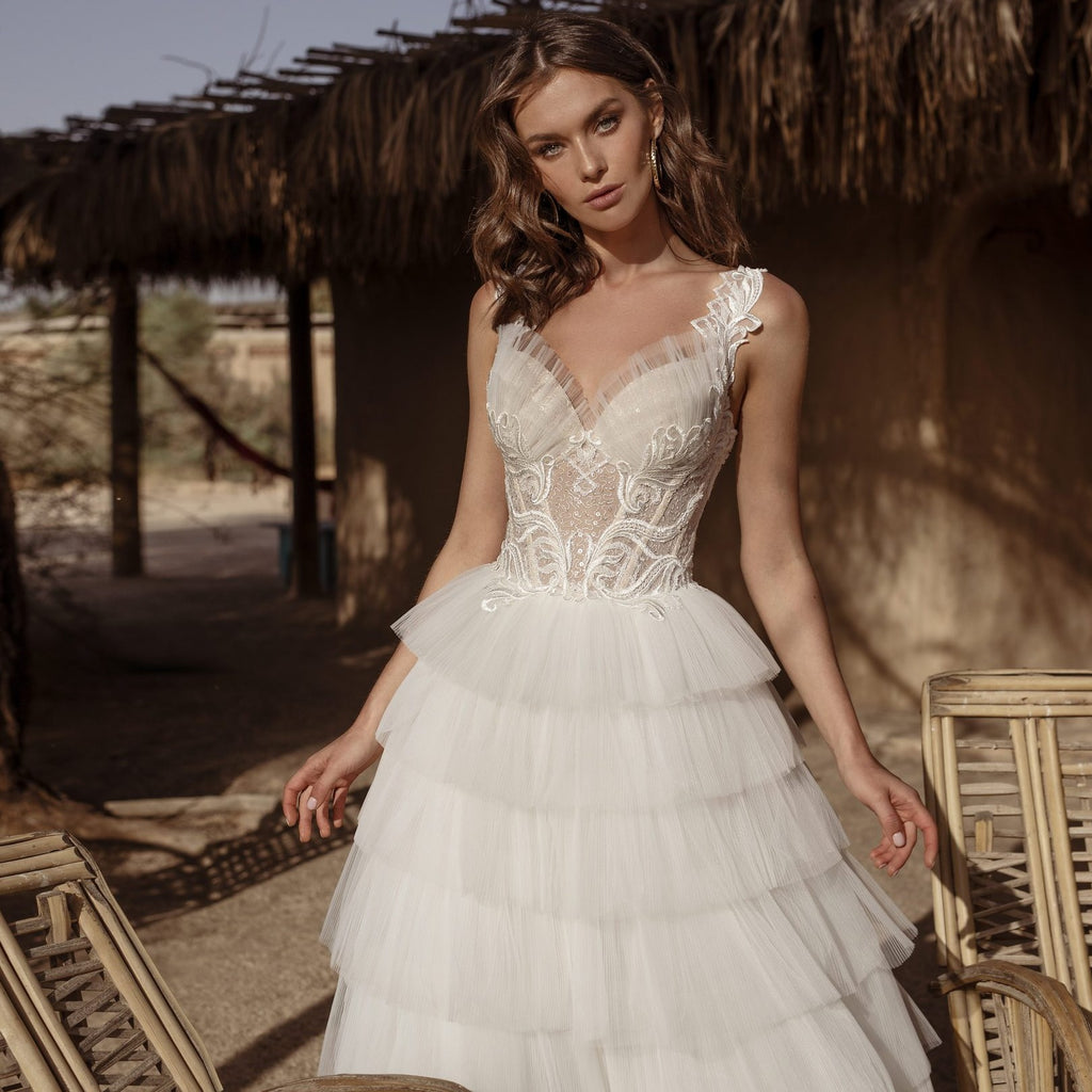 Look stunning on your wedding day in Robe Aluisa. This beautiful desert-style bridal gown features a ruffled line and sleeveless design, perfect for any wedding occasion. Crafted from luxurious fabrics, this gown will make you feel like the beautiful, blushing bride you are.