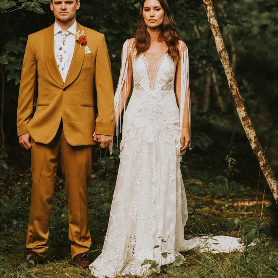 Experience pure elegance and bohemian charm with the Robe Posey. This unique wedding dress features ethereal tassel fringe and a deep V-neck, perfectly embodying the typical style of Rue. Feel like a true boho bride in this beautifully crafted bridal gown.