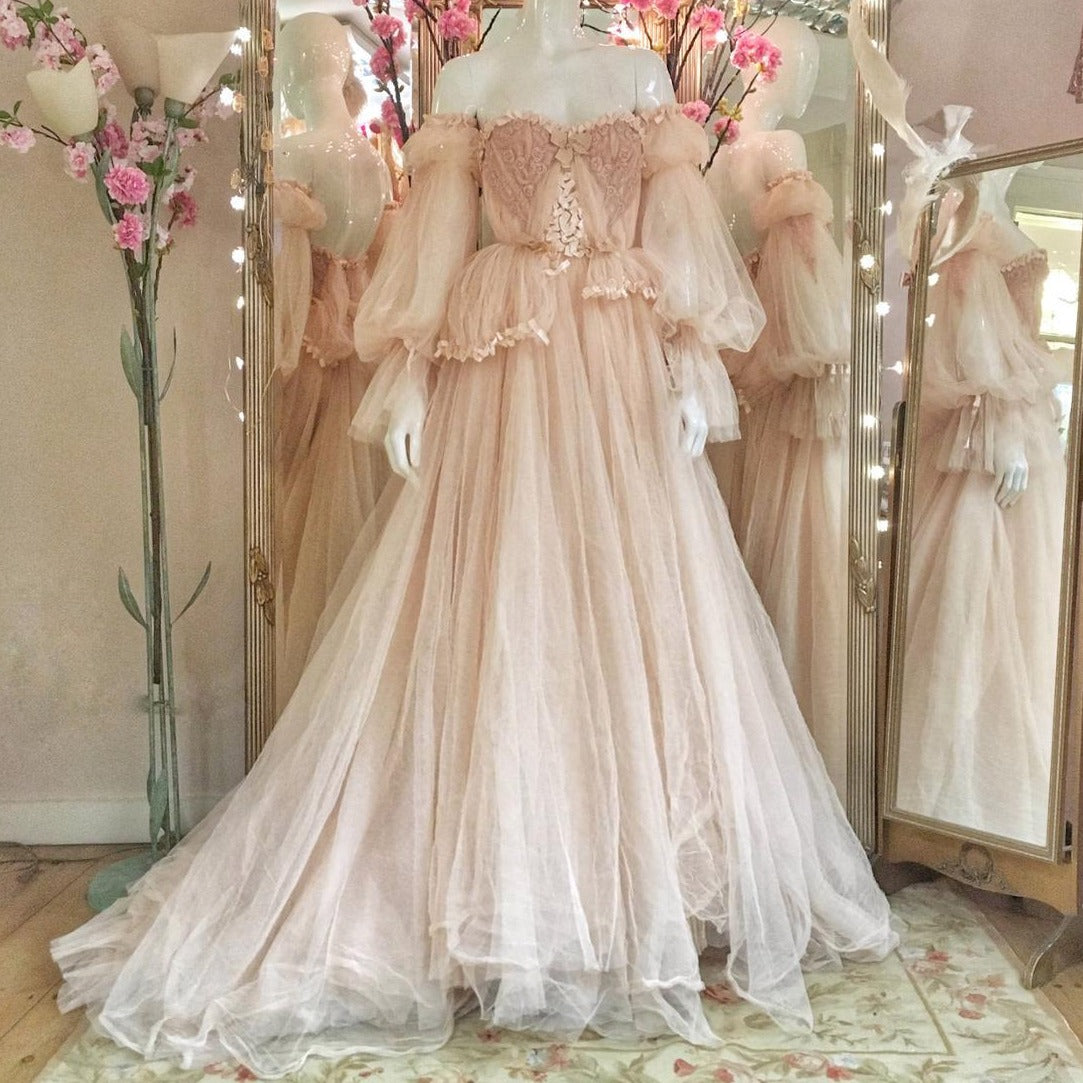 Indulge in the fanciful charm of the Robe Denisse. This beautiful ball gown dress, made of soft pink tulle, will transform you into a princess for any special occasion. Say yes to whimsy and grace in this stunning robe. (Tiara not included!)