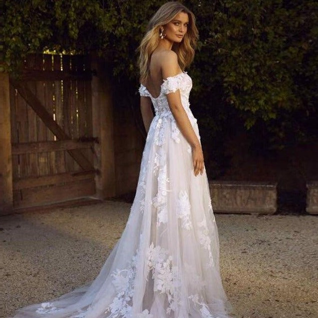 "Dress to impress in our Robe Nadege! This elegant gown features delicate white lace with beautifully embroidered flower details. Perfect for your dreamy wedding, this dress will make you feel like a true fashionista."