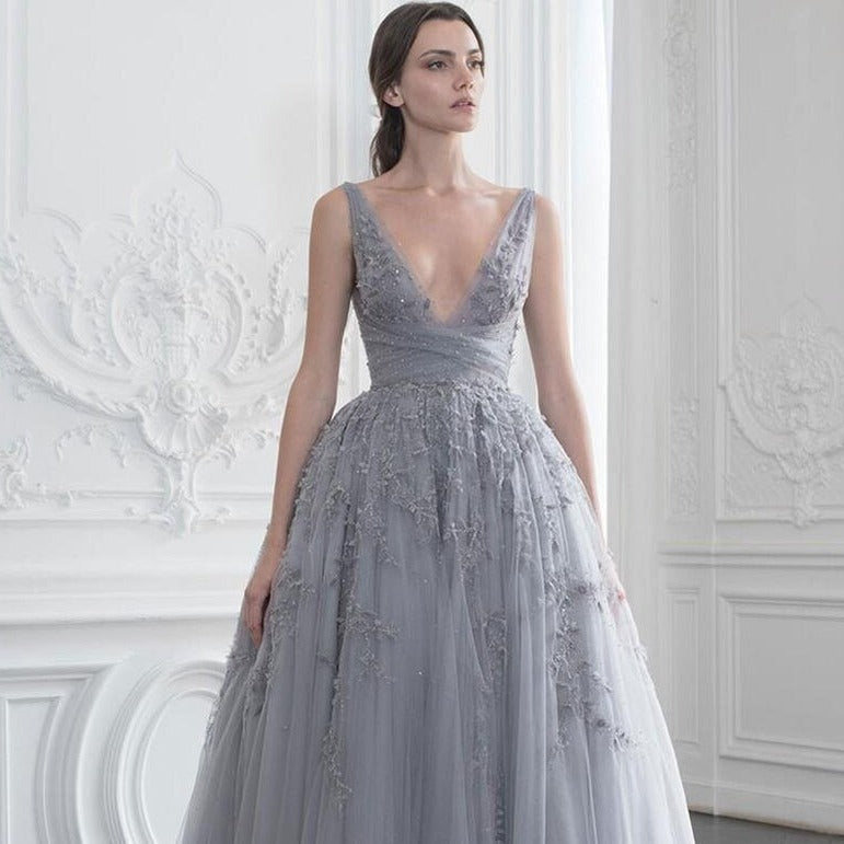 The 'Robe Vivienne' is a luxurious tea length evening gown crafted from delicate material and embellished with sparkling beading. Its sheer elegance and sophistication make it perfect for any formal event, capturing the beauty and poise of the modern woman.