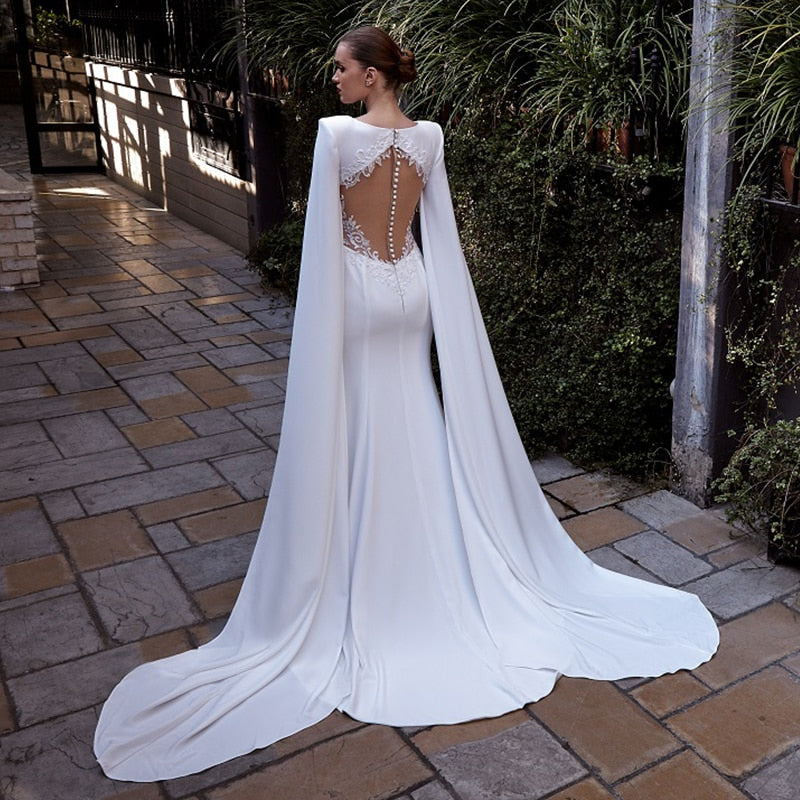 Experience elegance and beauty with our Robe Hettie. This cape gown bridal marriage dress is perfect for your special day. With its exquisite design, you'll feel like royalty as you walk down the aisle. Make your wedding day even more magical with our stunning Robe Hettie.