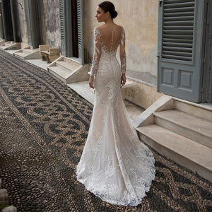 Indulge in the luxury of the Robe Neila. With its elegant lace design, this bridal gown exudes sophistication and chic style. The open back and siren mermaid silhouette add a sexy touch, making you feel like a true siren on your special day. Elevate your bridal look with this exclusive piece.